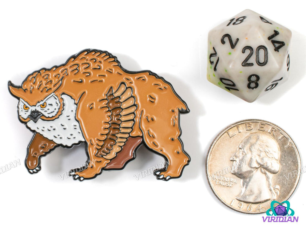 Close-up of Pin Pals: Owlbear (Version 2) enamel pin next to D20 die and quarter, showcasing detailed fantasy art design.