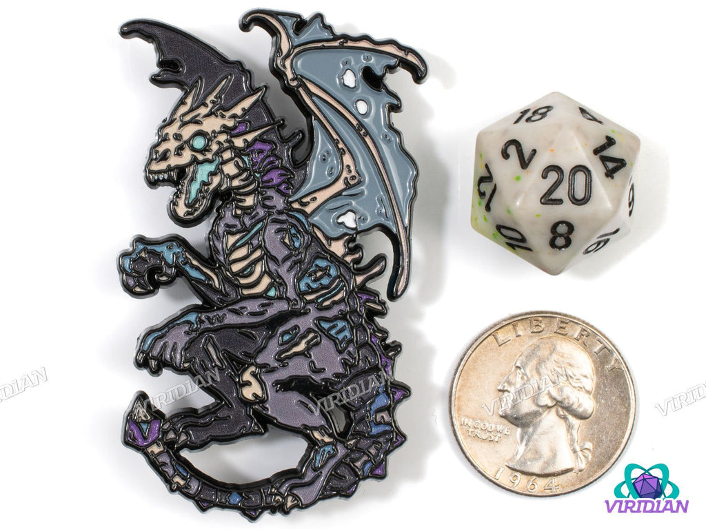 Close-up of Dracolich lapel pin next to a D20 die and US quarter, showcasing detailed undead dragon design for fantasy and DnD collectors.