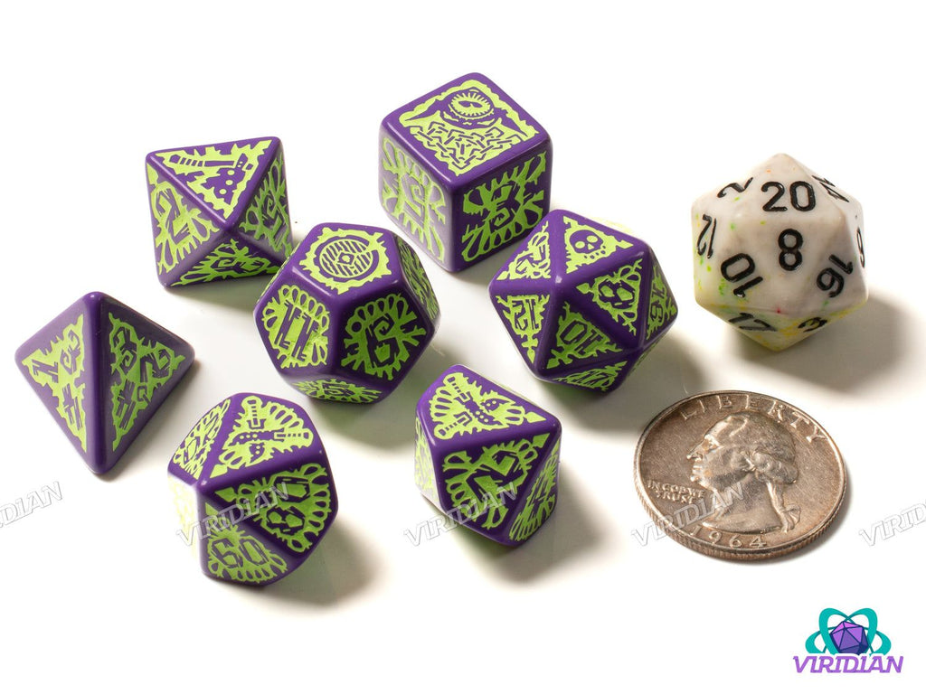 Pathfinder: Goblin 7-piece polyhedral dice set in green and purple shown next to a quarter and standard die for size comparison in tabletop games.