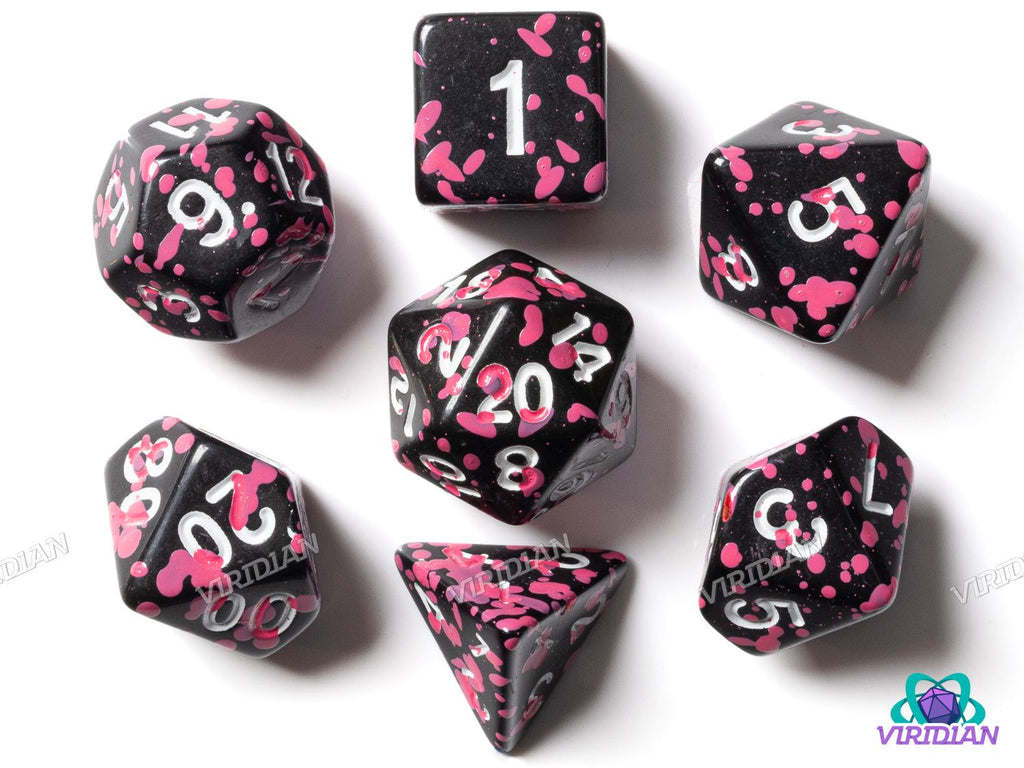 Pink Splatter polyhedral dice set with black base and white ink, featuring vibrant pink splatter design for tabletop RPG games.